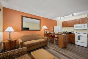 a living room with a couch and a kitchen at Affordable Suites of America Stafford Quantico in Stafford