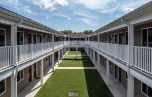 un patio vacío de un edificio escolar con césped verde en Affordable Suites of America Stafford Quantico, en Stafford