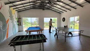 un hombre de pie en una habitación con dos mesas de ping pong en Haasienda 