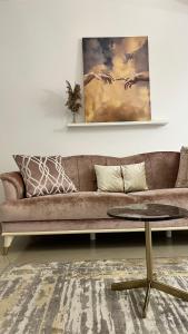 a brown couch in a living room with a table at Green Divine Apartament in Popeşti-Leordeni