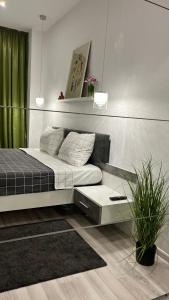 a bedroom with a bed and a green curtain at Green Divine Apartament in Popeşti-Leordeni