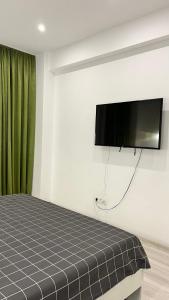 a bedroom with a bed and a flat screen tv at Green Divine Apartament in Popeşti-Leordeni