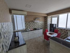 una cocina con encimera y sillas rojas. en SResidence, en Tiflis
