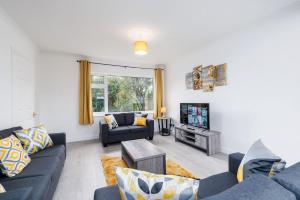 sala de estar con sofás azules y TV en Spacious Modern Home in Sheffield, en Todwick