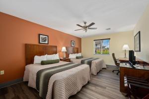 a hotel room with two beds and a ceiling fan at Affordable Suites of America Stafford Quantico in Stafford