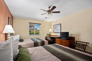 ein Hotelzimmer mit 2 Betten und einem Deckenventilator in der Unterkunft Affordable Suites of America Stafford Quantico in Stafford