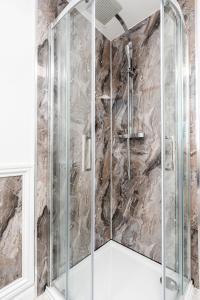 a shower in a bathroom with a stone wall at Spacious Modern Home in Sheffield in Todwick