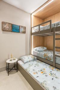 a bedroom with two bunk beds and a table at Eco Resort Praia dos Carneiros Apt Luxo Beira Mar in Tamandaré +37 photos