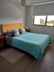 a bedroom with a large bed with a blue comforter at Vista Bahia Tomé in Tomé
