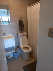 a bathroom with a toilet and a sink at Vista Bahia Tomé in Tomé