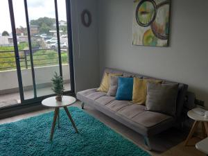 a living room with a couch and a large window at Vista Bahia Tomé in Tomé