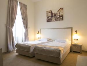a bedroom with two beds and a large window at Euro Hotel Grivita in Bucharest
