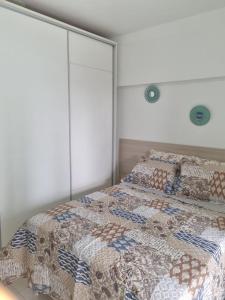 a bedroom with two beds with a quilt on it at 1/4 na praia de Armação in Salvador