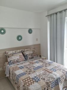 a bedroom with a bed with a quilt and pillows at 1/4 na praia de Armação in Salvador