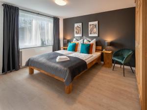 a bedroom with a bed with blue pillows and a window at Ferienwohnung Flensburg in Flensburg