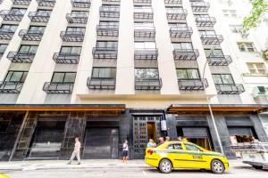 ein gelbes Taxi, das vor einem hohen Gebäude parkt in der Unterkunft 360 Rio Santos Dumont in Rio de Janeiro