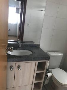 een badkamer met een wastafel en een toilet bij Apartamento central aconchegante.Sinta-se em casa! in Guarapuava