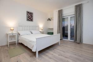 a white bedroom with a white bed and a window at Kuća za odmor Kamenjani-Škabrnja in Škabrnje +80 photos
