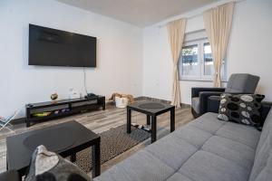 a living room with a couch and a flat screen tv at Kuća za odmor Kamenjani-Škabrnja in Škabrnje