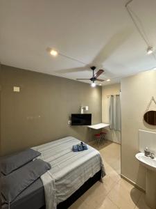 a bedroom with a bed and a sink and a ceiling fan at POUSADA CASA DA FÉ in Aparecida