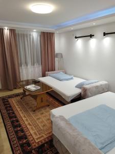 una camera d'albergo con due letti e un tavolino di Villa Amer Lux Apartments a Sarajevo