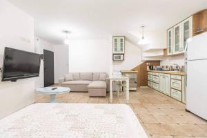 a living room with a couch and a kitchen at Lola House in Kefar H̱ittim