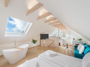 a white room with a bed and a bath tub at Ferienwohnung Flensburg in Flensburg