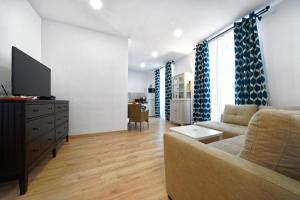 een woonkamer met een bank en een tv bij Casa Ingenio - Exclusive Facility in Ingenio