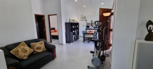 a living room with a black couch and a kitchen at Wis Villa in Galle