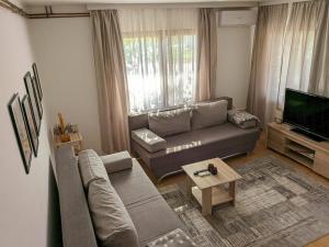 a living room with a couch and a television at Duplex House in Bijeljina