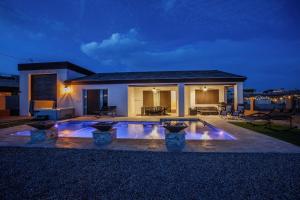 une maison avec une piscine la nuit dans l'établissement Desert Oasis a McCulloch Pool Home, à Lake Havasu City