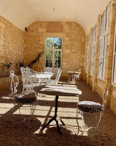 un patio con mesa y sillas en un edificio en Château Le Repos en Rouffignac-de-Sigoulès
