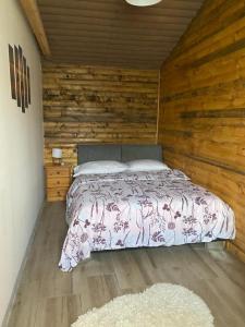 a bedroom with a bed and a wooden wall at Horizonti Miroc in Donji Milanovac