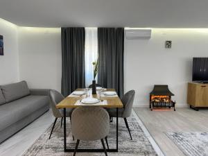 comedor con mesa con sillas y sofá en Rozi apartments, en Zagreb