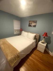a bedroom with a white bed and a blue wall at Cozy Boston Getaway Apartment! Free Parking in Boston
