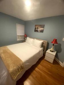 a bedroom with a white bed and a blue wall at Cozy Boston Getaway Apartment in Boston