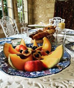 une table avec une assiette de fruits sur une table dans l'établissement Château Le Repos, à Rouffignac-de-Sigoulès
