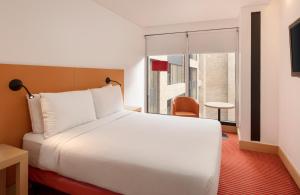 a hotel room with a large bed and a window at Fairfield by Marriott Bogota Embajada in Bogotá