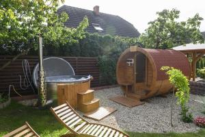 een tuin met een hot tub en een houten huis bij Pensjonat Srebrny Klon in Bytów