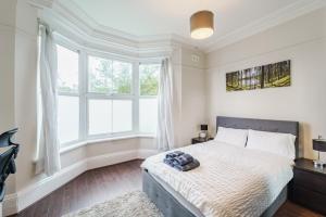 um quarto com uma cama grande e janelas em Augusta lodge Moseley em Birmingham