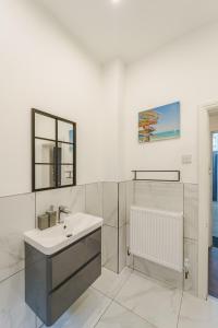 a white bathroom with a sink and a mirror at Augusta lodge Moseley in Birmingham