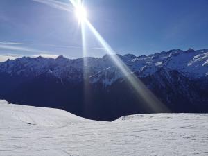 a sun is shining on a snow covered mountain at Bagneres de luchon Hyper Centre in Luchon