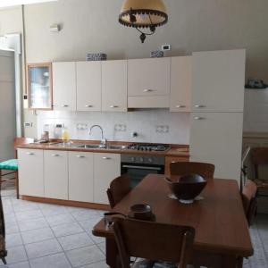 kuchnia z białymi szafkami i stołem z miską w obiekcie Dimora Palma di Barolo w mieście Barolo