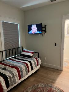 ein Schlafzimmer mit einem Bett und einem TV an der Wand in der Unterkunft The Clifford House in Pensacola