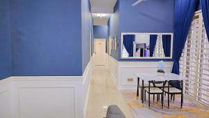 a hallway with a table and a blue wall at Homestay By MSH Seri Iskandar in Seri Iskandar
