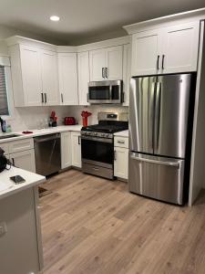 a kitchen with white cabinets and a stainless steel refrigerator at The Clifford House in Pensacola