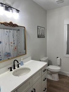 a white bathroom with a sink and a toilet at The Clifford House in Pensacola