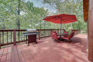 a patio with a table and chairs and an umbrella at Fort Towson Cabin Less Than 1 Block to Raymond Gary Lake in Fort Towson