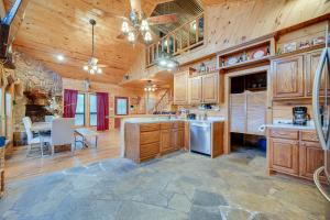 a kitchen with wooden cabinets and a dining room with a table at Fort Towson Cabin Less Than 1 Block to Raymond Gary Lake in Fort Towson