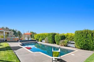 陶波Mountviews Lodge的院子里有带遮阳伞的游泳池